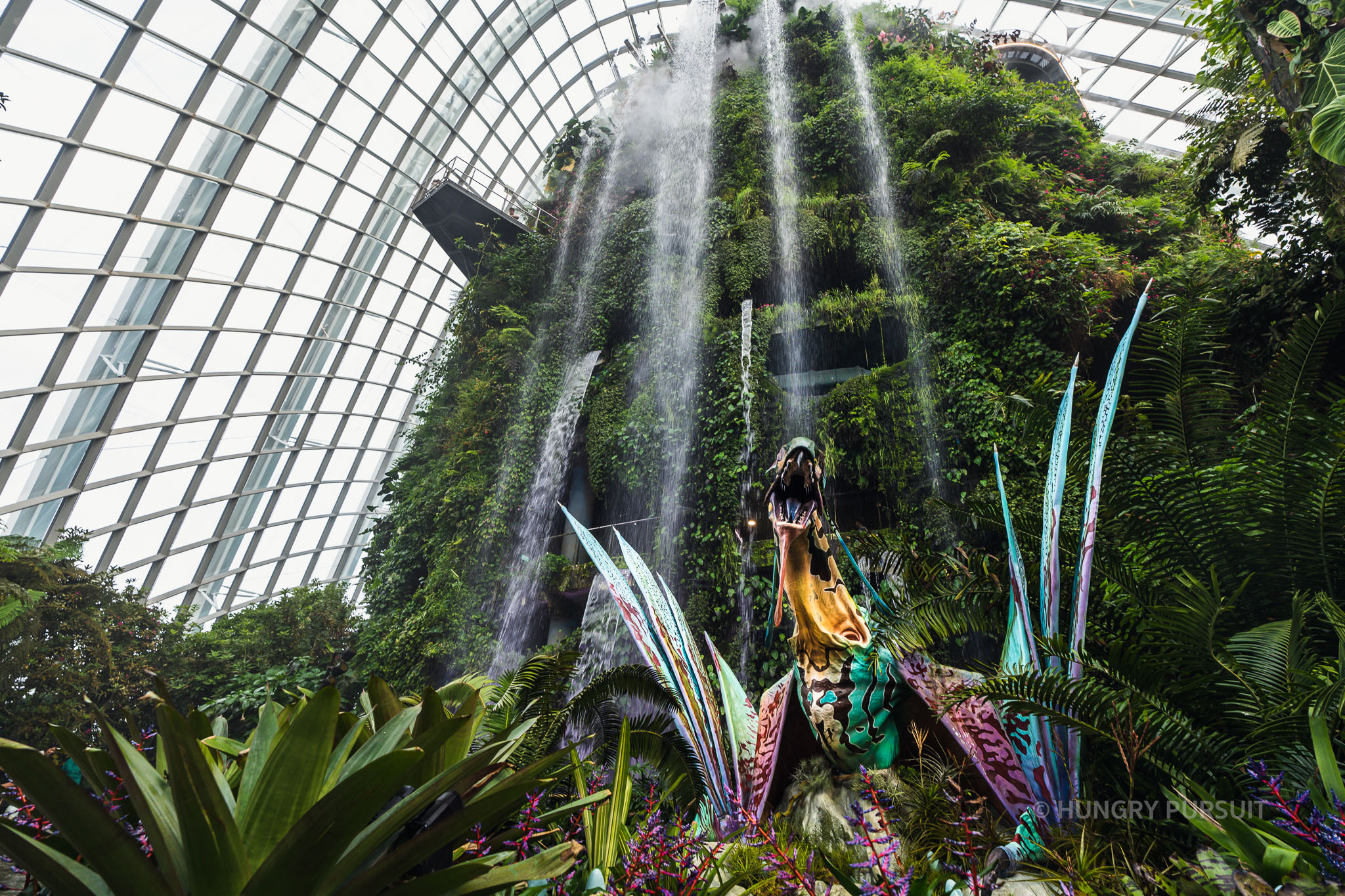 Ultimate Singapore travel guide Interior view of the Cloud Forest dome, featuring lush greenery and waterfall at Gardens by the Bay, Singapore Avatar Experience
