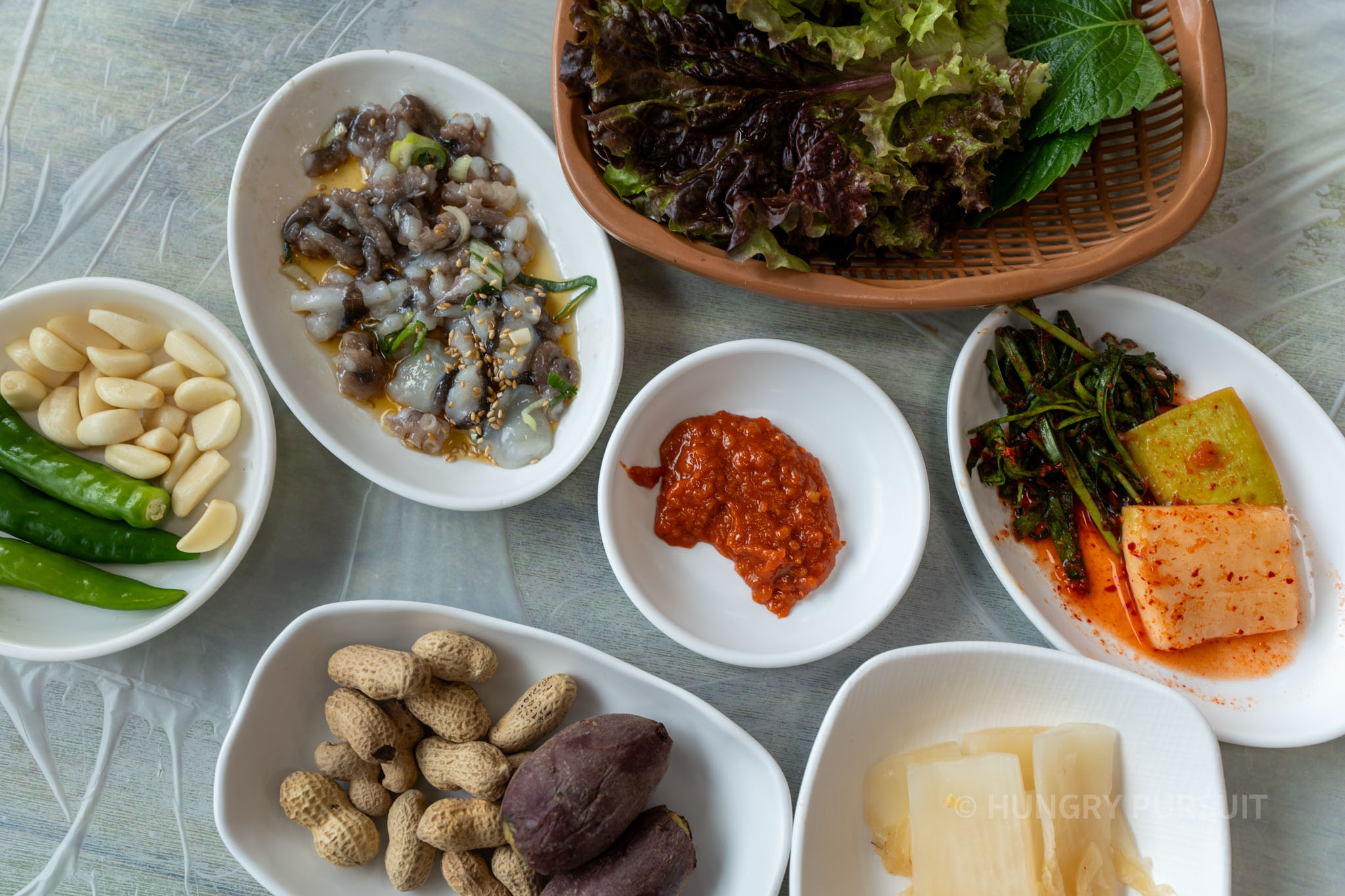 a table of korean side dishes at the jagalchi market restaurant.