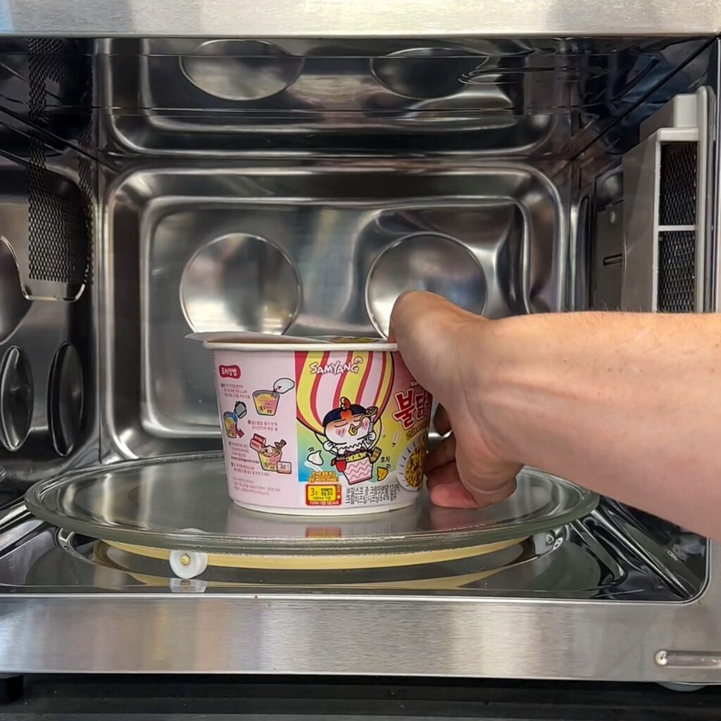 placing ramen inside a microwave inside a Korean convenience store.