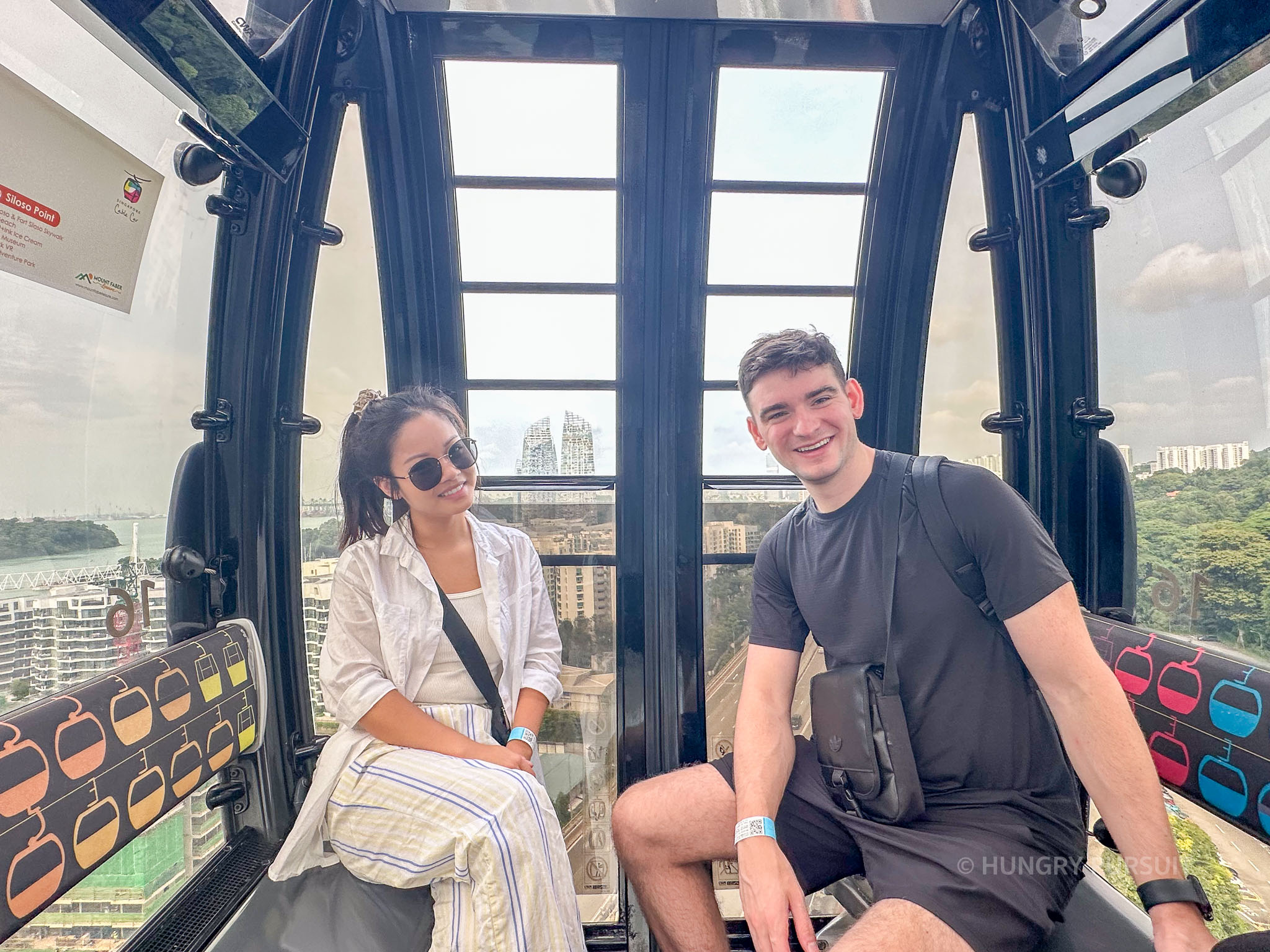 Couple enjoying a cozy moment inside the cable car, high above the skyline of Singapore.