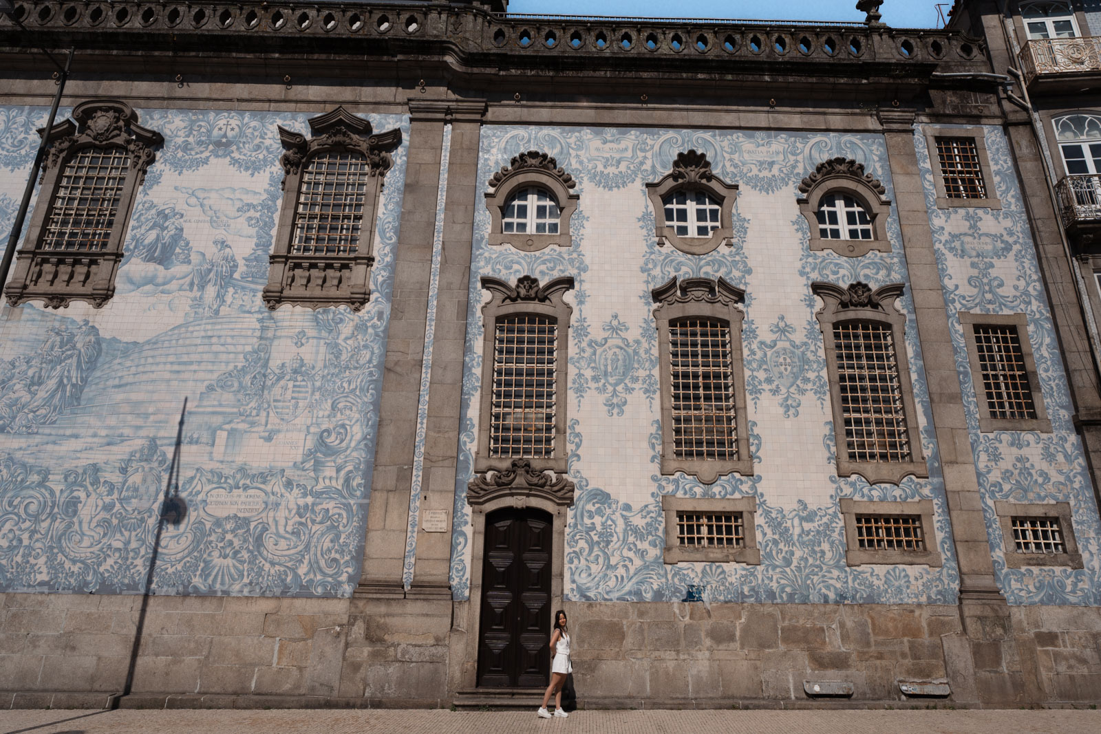 a woman posing in front of blue and white tile wall of church, Igreja do carmo, 1 day in Porto