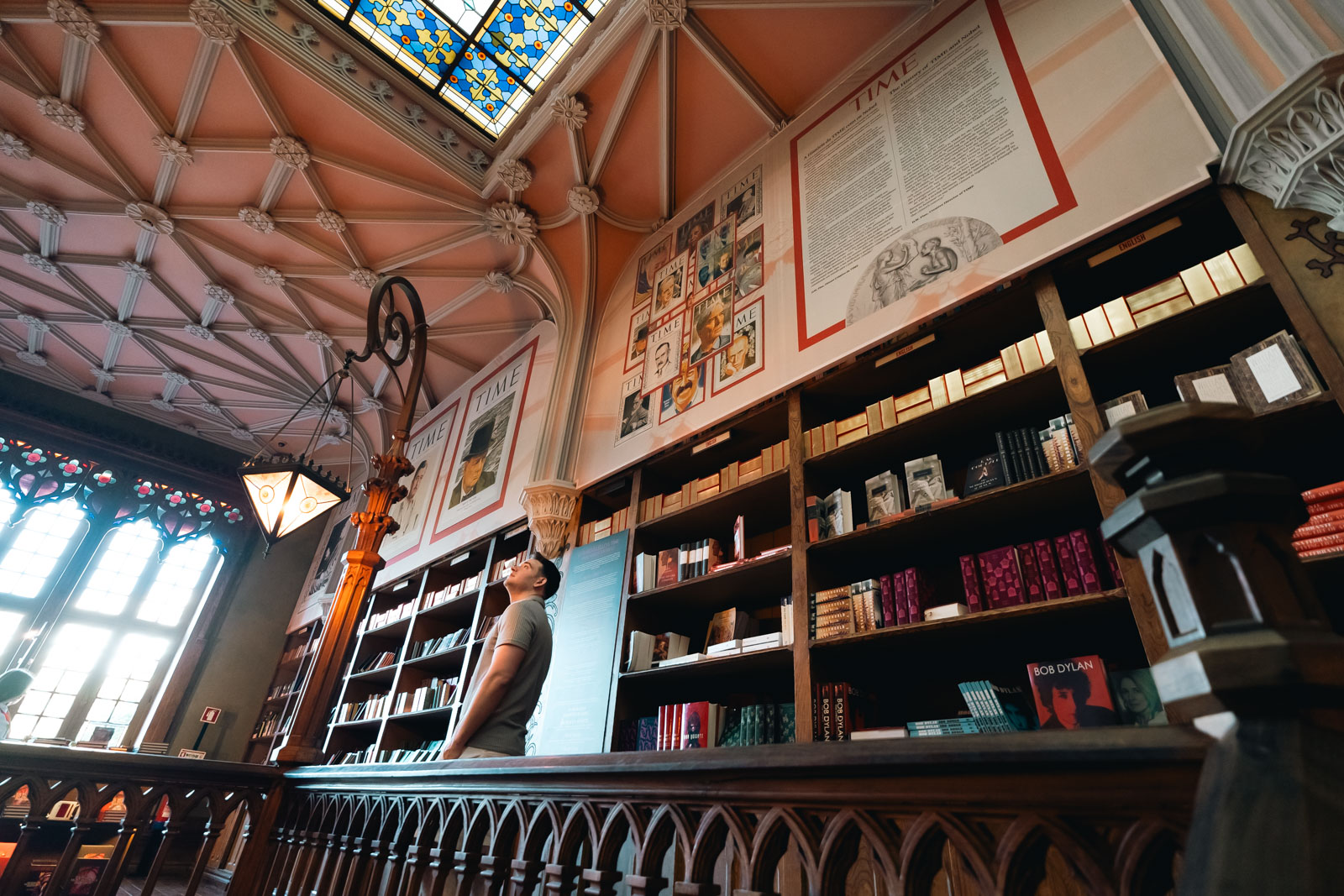 A man observing the books in livraria lello bookstore in porto; 2 days in porto itinerary.