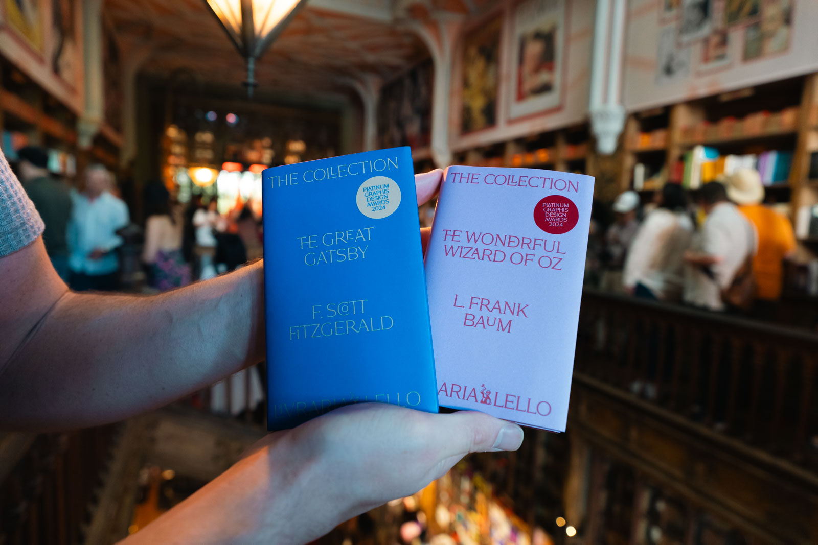 a man holding two books at a bookstore,livraria lello, 1 day in porto