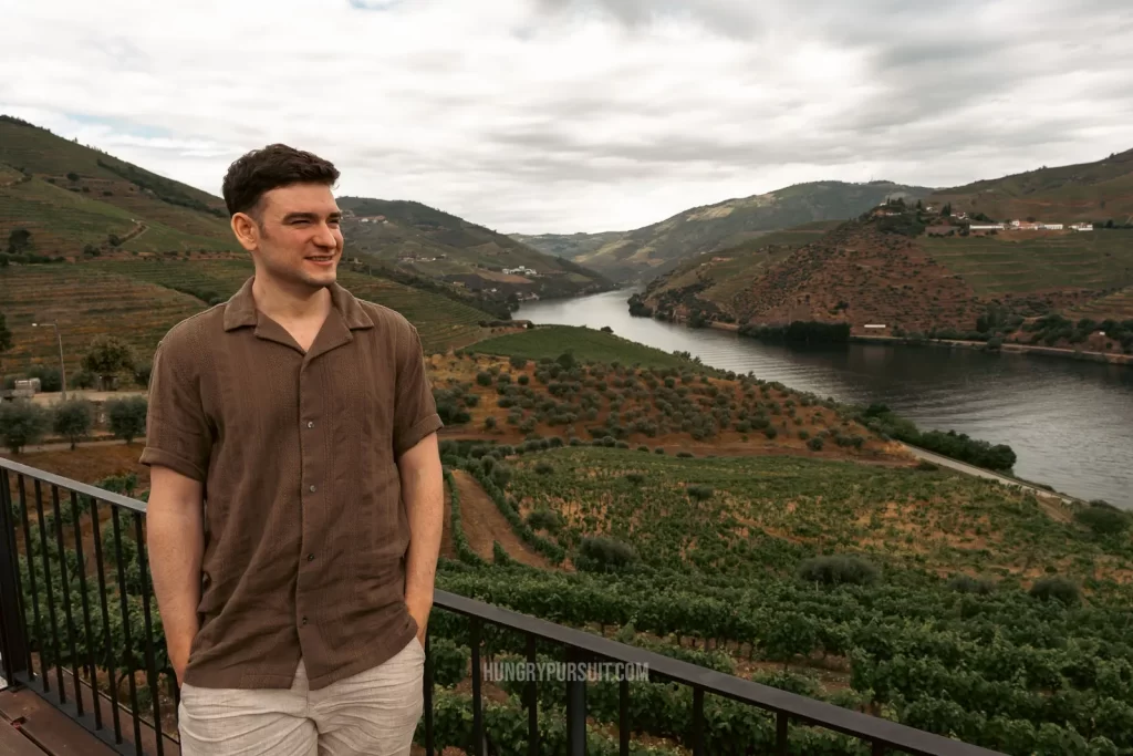 a man standing overlooking the vineyards on best douro valley wine tour; at douro valley wine tasting.