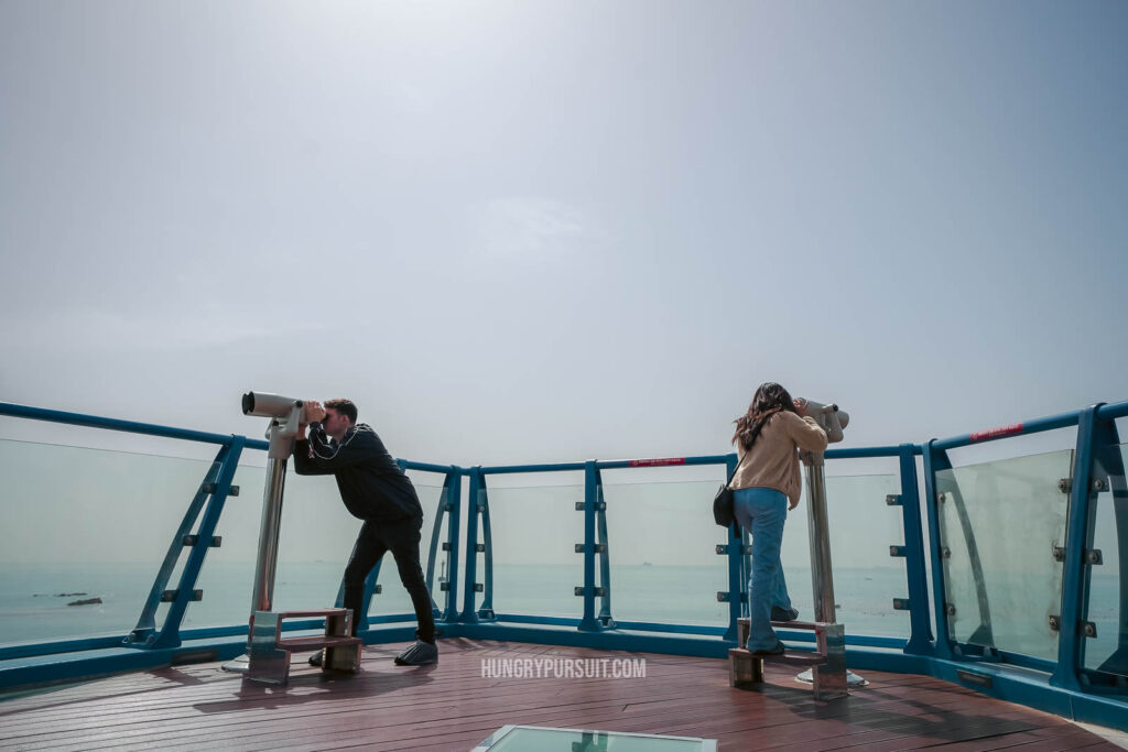 A man and women using telescopes at Cheongsapo Daritdol Observatory at Haeundae Blueline Park.