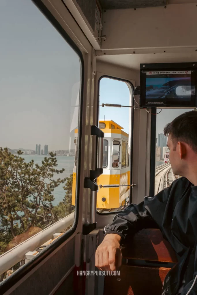 a man inside a Haeundae sky capsule at Haeundae blueline park photos