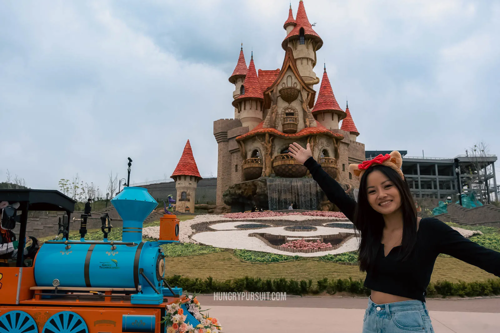 a woman standing in front ofa castle at lotte world adventure busan; things to do in busan