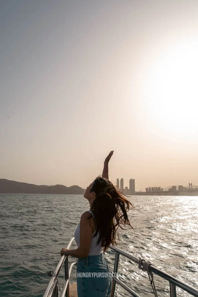 girl with arms in the sky on busan yacht cruise