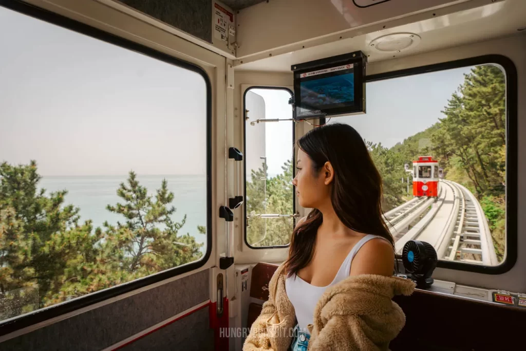 a woman inside a haeundae sky capsule at haeundae blueline park